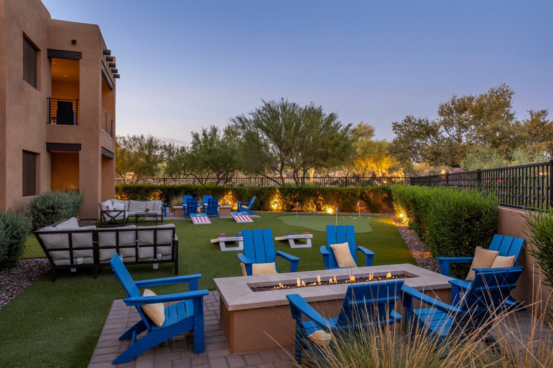 Outdoor putting green, fire pit, and lawn gathering area
